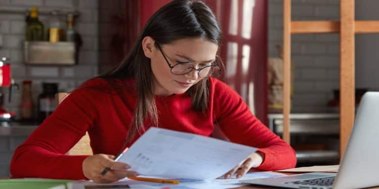 Estudante revisa anotações de gramática ao conferir o plural de palavra-chave e de outros substantivos compostos