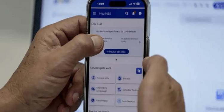 Mãos segurando celular aberto no app Meu INSS com tela de serviços e botão “Consultar Benefício”, simbolizando os serviços do Meu INSS.