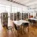 Biblioteca universitária com mesas de estudo e estantes de livros representando as diferenças entre faculdade e universidade.